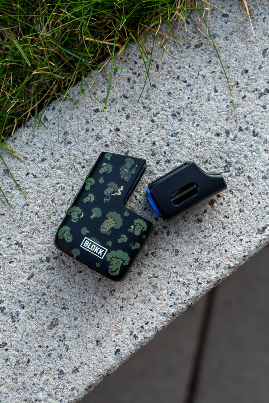 BLOKK Vaporizer mit Brokkoli-Design und Dosierkapsel, aufgenommen im urbanen Outdoor-Setting auf Betonfläche