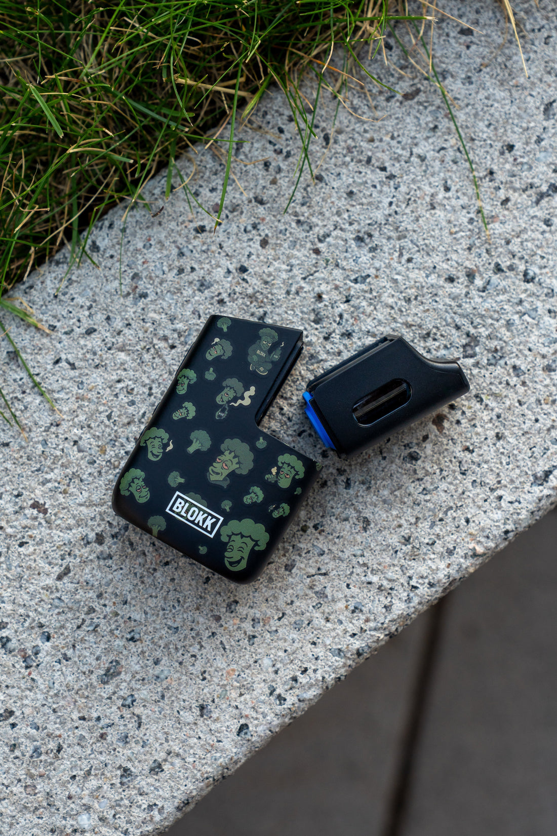 BLOKK Vaporizer mit Brokkoli-Design und Dosierkapsel, aufgenommen im urbanen Outdoor-Setting auf Betonfläche